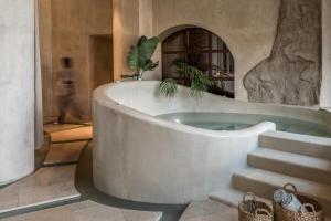 a bath tub in a room with stairs at Acro Suites - A Wellbeing Resort in Agia Pelagia