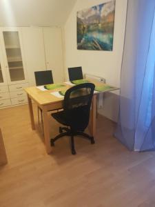 a wooden table with a black chair and a desk at Wohnung Bornstraße in Freigericht