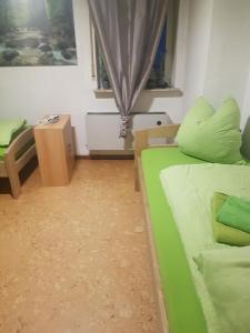 a small room with a green bed and a table at Wohnung Bornstraße in Freigericht