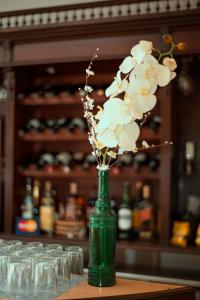 a green vase with white flowers in it on a table at Hotel Argon in Dolores