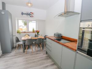 a kitchen with a table and a dining room at 54 Pencoed Road in Burry Port