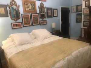 a bedroom with a large bed with pictures on the wall at Abbot's Wing in Stroud