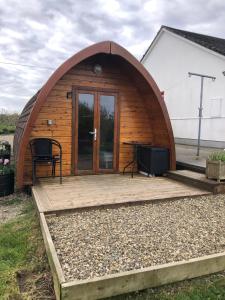 a wooden iguana house with a table and a desk at The Rainbow POD in Milltown Malbay
