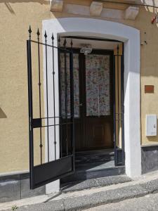 una entrada a un edificio con una puerta de hierro forjado en House Umberto I, en Viagrande