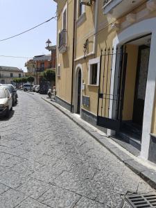 una calle adoquinada frente a un edificio en House Umberto I, en Viagrande