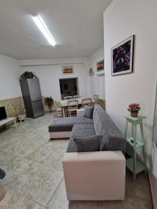 ein Wohnzimmer mit einem Sofa und einem Tisch in der Unterkunft House Umberto I in Viagrande