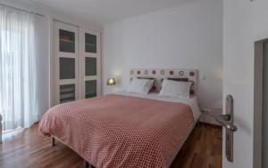 a white bedroom with a large bed with a red blanket at Beach Park Apartments in Luz