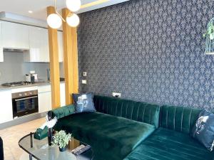 a green couch in a living room with a table at Anfa Living 29-The Gatsby 5 Chic&New Apt near Sea in Casablanca