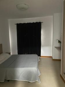 アレシーフェにあるApartamentos Carlota IIのベッドルーム1室(ベッド1台付)、窓(黒いカーテン付)