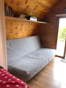 Bett in einem Zimmer mit einer Holzwand in der Unterkunft The Rainbow POD in Miltown Malbay