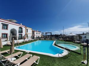 basen z leżakami obok budynku w obiekcie Billy's Marina 360 with pool access w mieście Puerto de Mogán