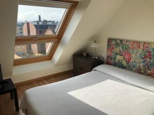 ein Schlafzimmer mit einem Bett und einem großen Fenster in der Unterkunft Apartamento para 6 personas con piscina y paddle in Foz