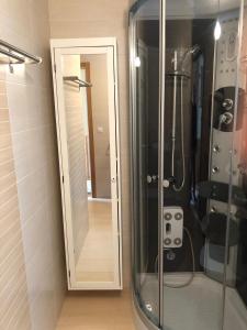 eine Glasdusche mit Spiegel im Bad in der Unterkunft Apartamento para 6 personas con piscina y paddle in Foz + 13 Fotos
