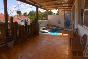 een woonkamer met een houten vloer en een patio bij Eilat super terrace and garden apartment in Eilat
