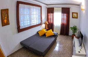 uma sala de estar com um sofá com almofadas amarelas em Flor del Drago em Icod de los Vinos