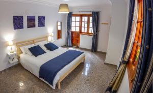 a bedroom with a large bed with blue pillows at Flor del Drago in Icod de los Vinos