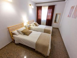 a hotel room with two beds and a window at Flor del Drago in Icod de los Vinos +19 photos