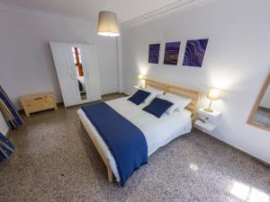 a bedroom with a large bed with blue and white sheets at Flor del Drago in Icod de los Vinos