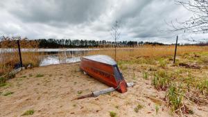 a boat sitting in the sand near a body of water at Przystanek Orle in Gorczyca +17 photos