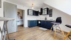 a kitchen with blue cabinets and a staircase at Przystanek Orle in Gorczyca