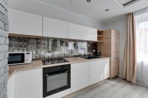 een keuken met witte kasten en een magnetron bij Comfort Apartments Old Town Grobla in Gdańsk