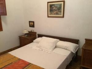uma cama com duas almofadas num quarto em Cortijo de la Fuente em Albuñol