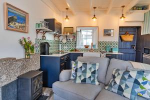 
a living room filled with furniture and decor at Cosy Mousehole Cottage With Sea Views in Mousehole
