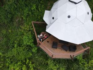 a white umbrella sitting on top of a green lawn at Trekker Glamping in Minca