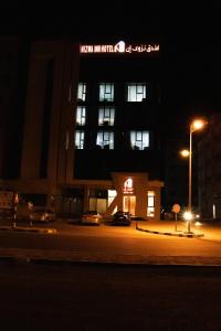 budynek z znakiem na boku w nocy w obiekcie Nizwa Inn - نزوى إن w mieście Nizwa