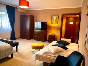 a bedroom with two beds and a television in it at Pensiunea Marylou in Alba Iulia