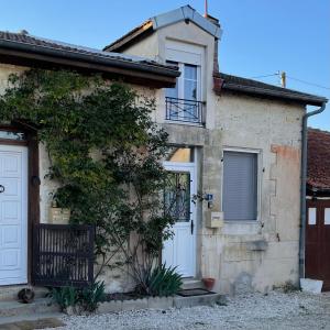 una casa in pietra con porta bianca e balcone di Maison à louer Les Roses ad Arconville
