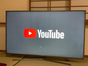 a large monitor with the youtube logo on it at Green House 101 in Tokyo