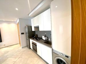 卡薩布蘭卡的住宿－Anfa living 06 - Luxury & Comfort near the Sea，厨房配有白色橱柜和一台洗衣机