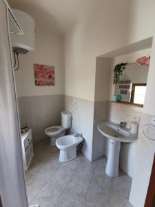 a bathroom with two sinks and a toilet at Loft San Mauro in Viagrande