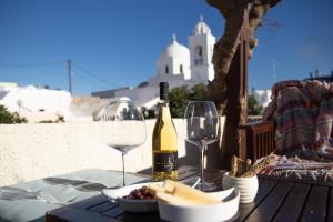 a table with a bottle of wine and wine glasses at Bougainville House in Megalokhori