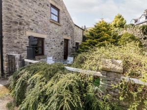an external view of the house with a large bush at The Olde Coach House in Bradwell