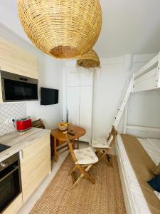 アルマカオ・デ・ペラにあるTiny Beach House Armação de Pêraのキッチン、テーブル、ベッドが備わる客室です。