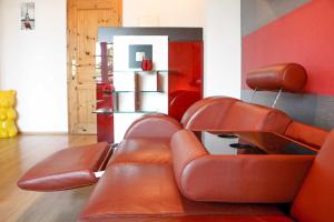 a living room with brown leather chairs and a refrigerator at Gaststaette & Pension Schinkenkrug in Hinrichshagen +51 photos