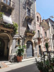 un vecchio edificio con balconi e piante su una strada di MiMì Luxury Home a Catania