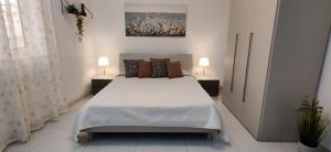 una camera da letto con un grande letto con due comodini di Lorenza Letting Maisonette a Marsaxlokk