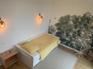 1 dormitorio con 1 cama con una planta en la pared en La Canopée de Mareil, en Mareil-Marly