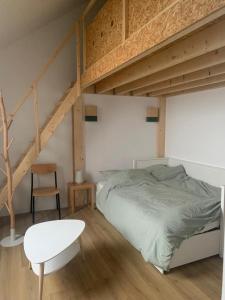 1 dormitorio con 1 cama elevada y 1 silla blanca en La Canopée de Mareil, en Mareil-Marly