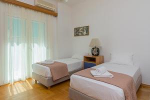 a bedroom with two beds and a window at Nice 2bedroom apartment in Pagkrati in Athens