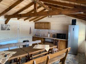 a kitchen with a table and a refrigerator at Вили Елеганс Сърница in Sarnitsa