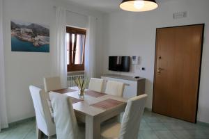 jadalnia ze stołem i białymi krzesłami w obiekcie Ganimede Apartament w mieście Sperlonga