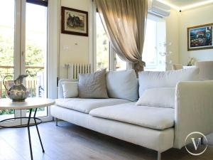 een woonkamer met een witte bank en een tafel bij Corso Roma, 37 - Valente Italian Properties in Montecatini Terme