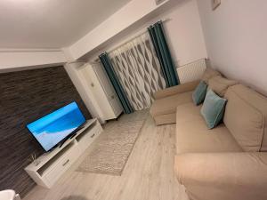 een woonkamer met een bank en een flatscreen-tv bij Eqinox apartments in Mamaia Nord – Năvodari