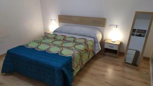 sypialnia z łóżkiem z niebieskim kocem i lustrem w obiekcie Atractivo apartamento en la playa con parking w mieście Roquetas de Mar +24 zdjęcia