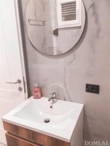 y baño con lavabo blanco y espejo. en Domi Beach Valley en Dhërmi
