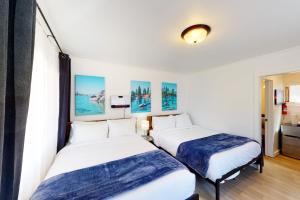 国王海滩The Chalet at Kings Beach Unit 1的一间白墙房间里有两张床